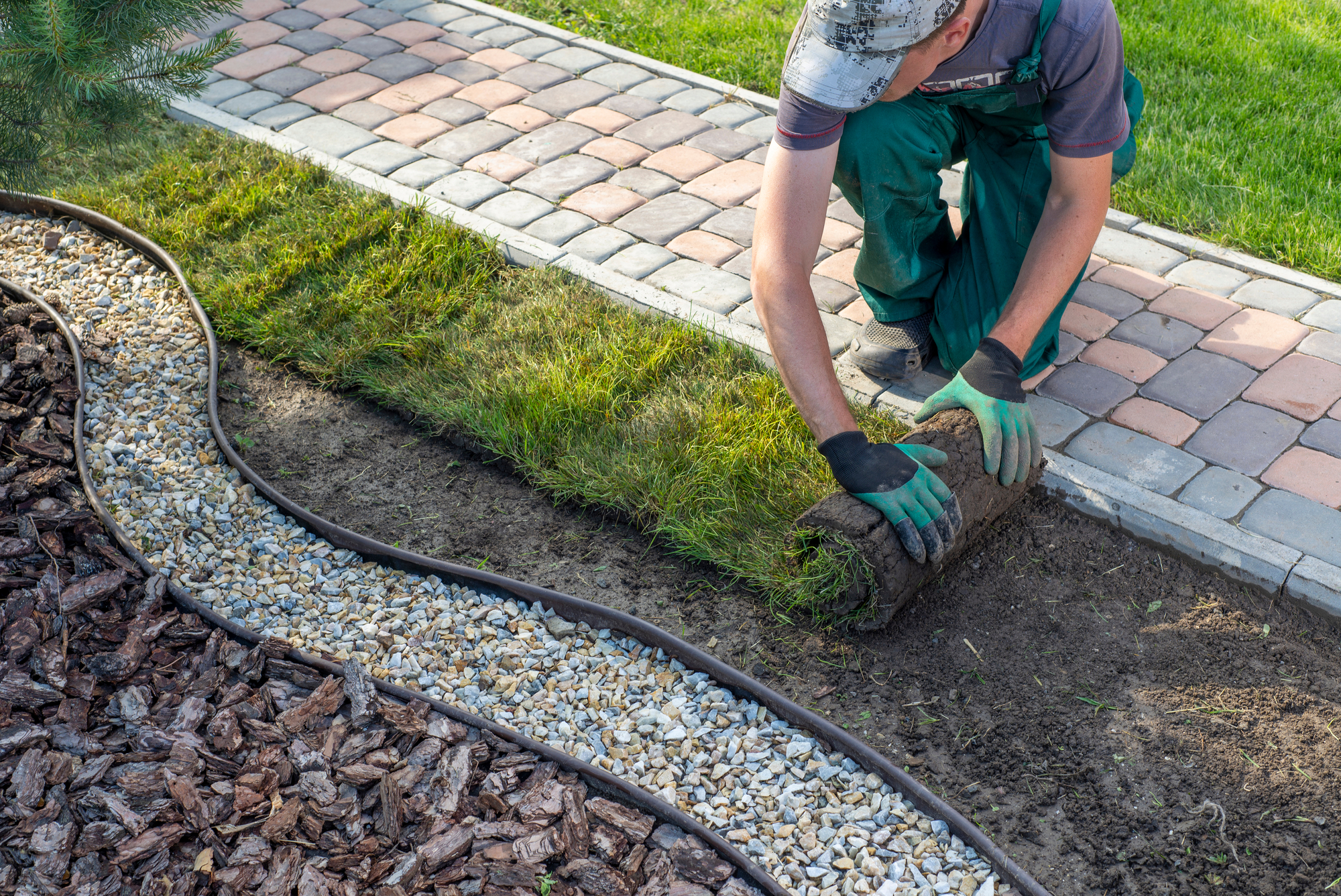 Landscaper Laying Out Rolled Grass